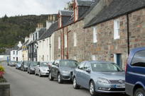 Lots of cars in front of picturesque houses